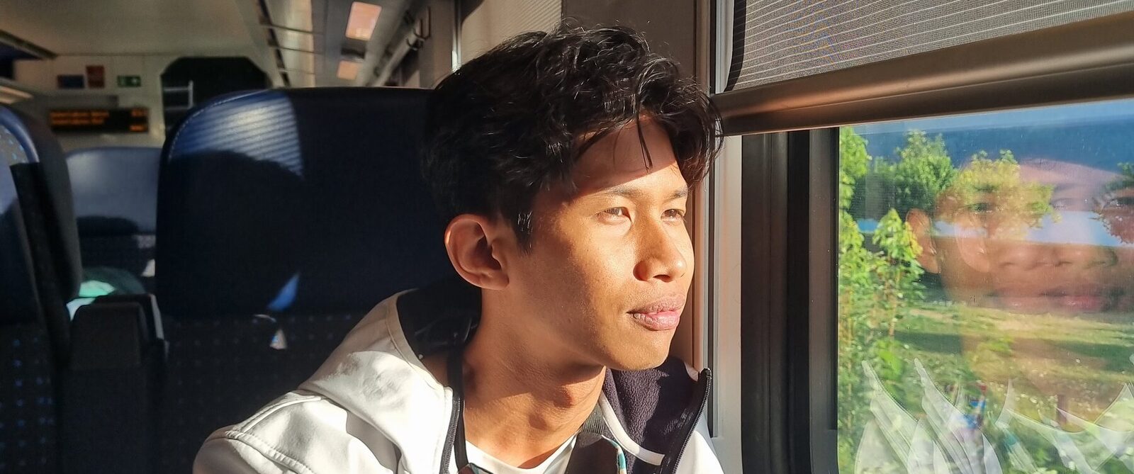 Portrait by a train window at golden hour